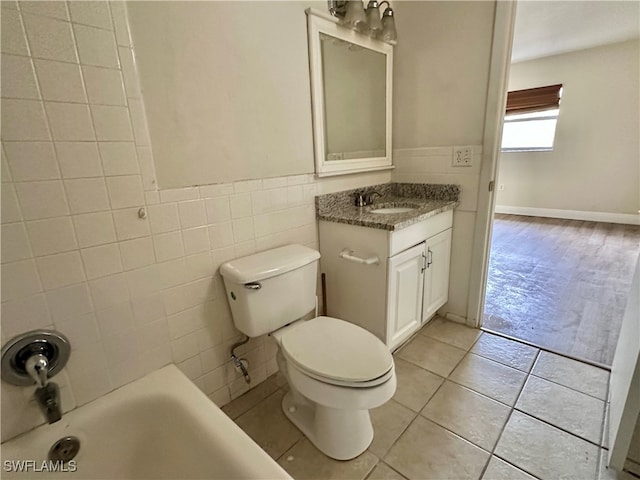 bathroom featuring tile patterned flooring, vanity, tile walls, and toilet