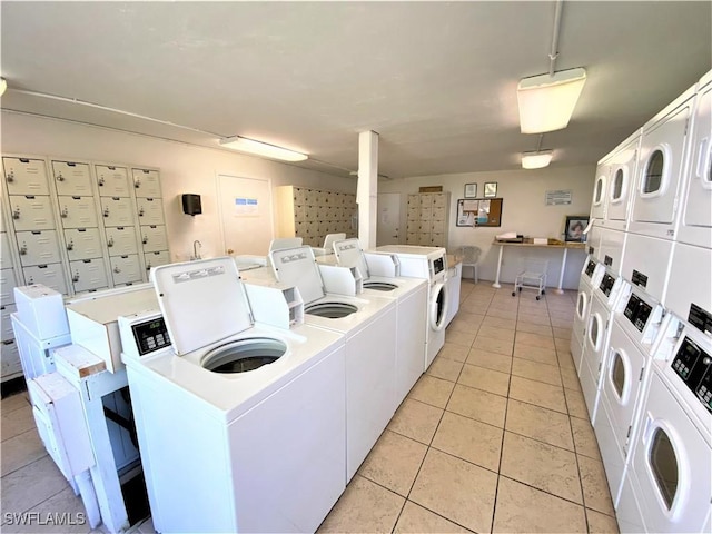 laundry area featuring stacked washer and dryer, washer and clothes dryer, and light tile patterned floors