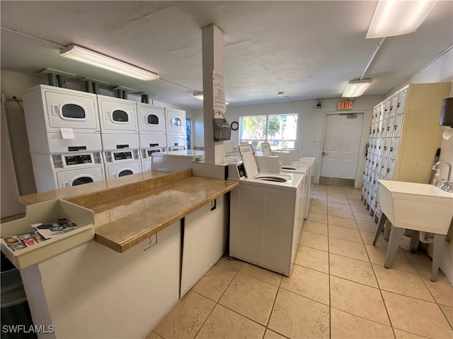 kitchen with stacked washer and dryer, mail boxes, white cabinetry, light tile patterned floors, and independent washer and dryer