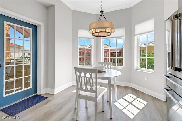 dining area featuring ornamental molding and light hardwood / wood-style floors