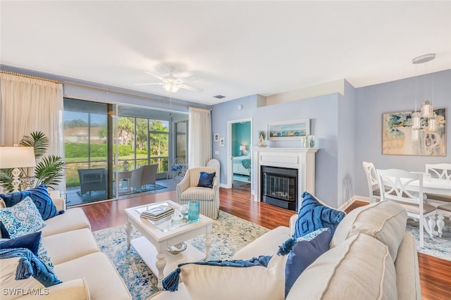 living room featuring ceiling fan and dark hardwood / wood-style floors