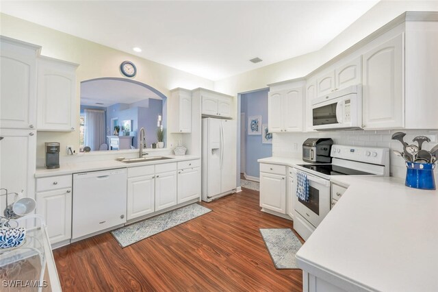 kitchen with white cabinetry, white appliances, tasteful backsplash, sink, and dark hardwood / wood-style floors