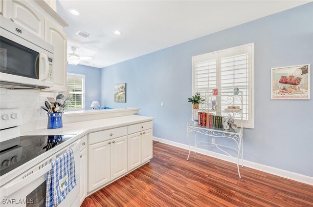 kitchen featuring white appliances, backsplash, ceiling fan, dark wood-type flooring, and white cabinets