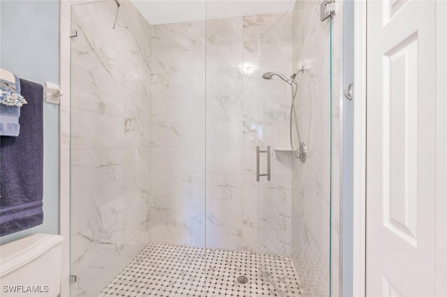 full bathroom with toilet and a marble finish shower