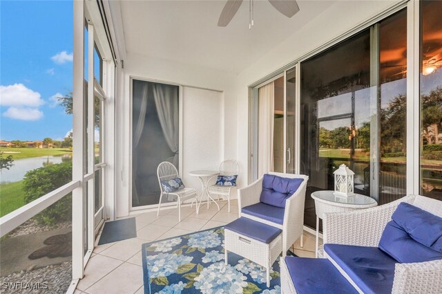 sunroom / solarium with plenty of natural light, a water view, and ceiling fan