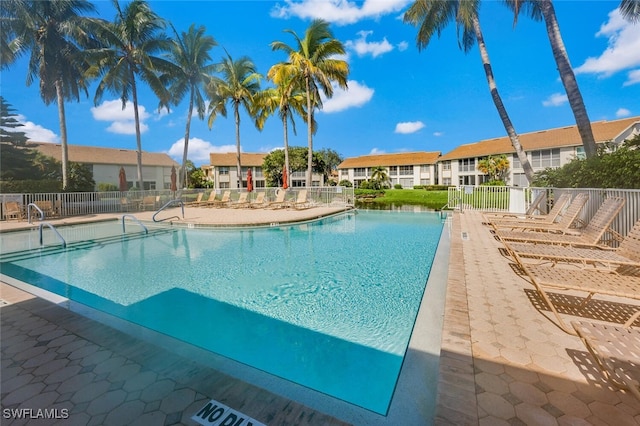 community pool featuring fence and a patio