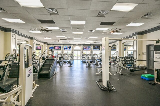 workout area featuring a paneled ceiling, ceiling fan, and ornamental molding