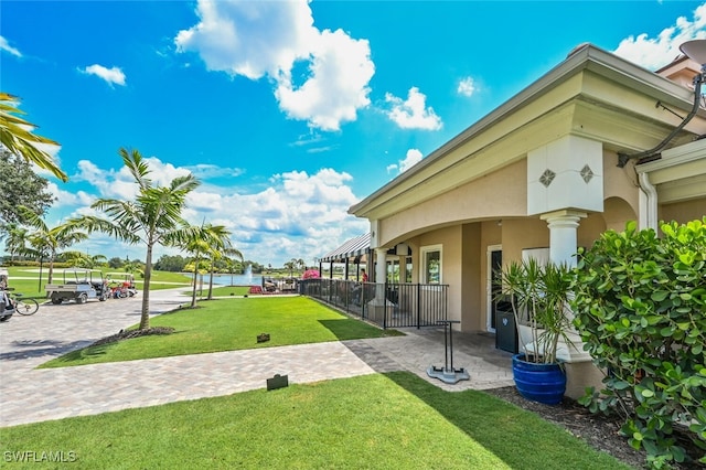 surrounding community with fence and a yard