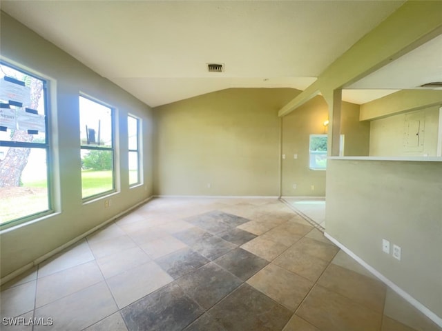 unfurnished room featuring vaulted ceiling and a healthy amount of sunlight