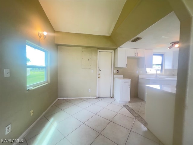 kitchen with sink, light tile patterned floors, and white cabinets