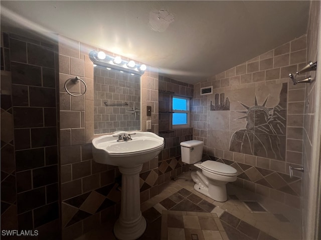 bathroom with lofted ceiling, tile walls, toilet, and tile patterned floors