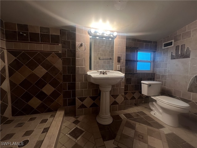 bathroom with tile walls, tile patterned flooring, and toilet