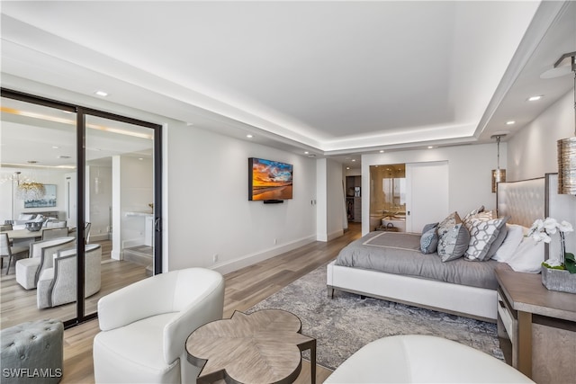 living room featuring a raised ceiling and light hardwood / wood-style flooring