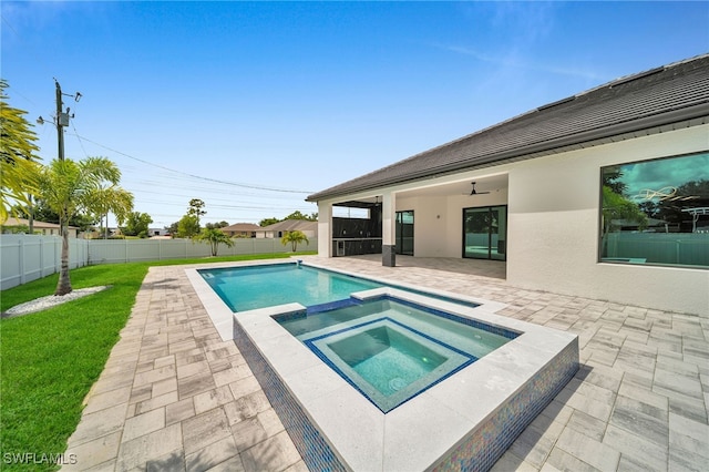 view of swimming pool with a lawn, ceiling fan, a patio, and an in ground hot tub