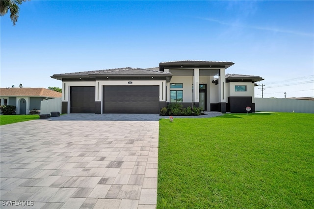 prairie-style house featuring a garage and a front lawn