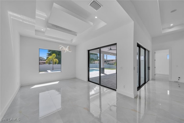 unfurnished room with a tray ceiling and a chandelier