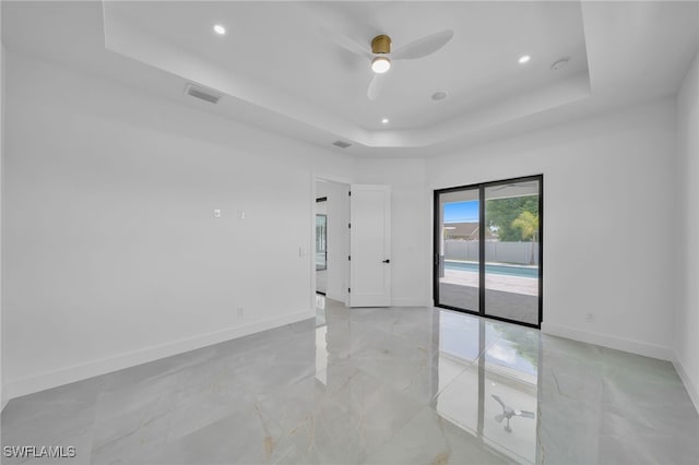 unfurnished room with a raised ceiling and ceiling fan