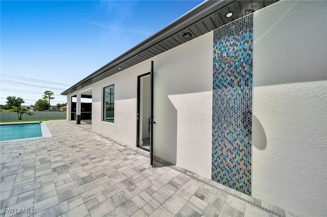 exterior space featuring a fenced in pool and a patio