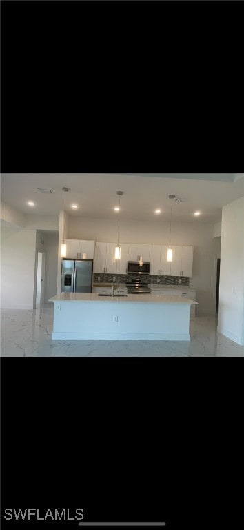 kitchen with stainless steel refrigerator with ice dispenser, pendant lighting, white cabinetry, and a center island