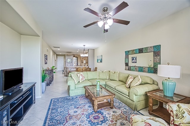 living room with light tile patterned floors and ceiling fan with notable chandelier