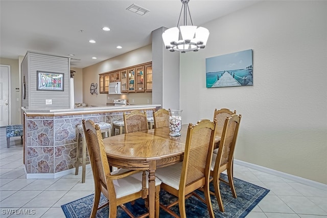 tiled dining area with a chandelier