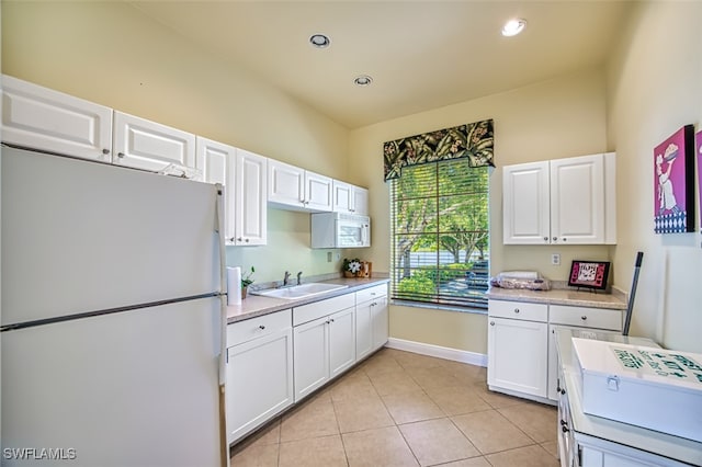 kitchen featuring sink, white cabinets, light tile patterned floors, and white refrigerator