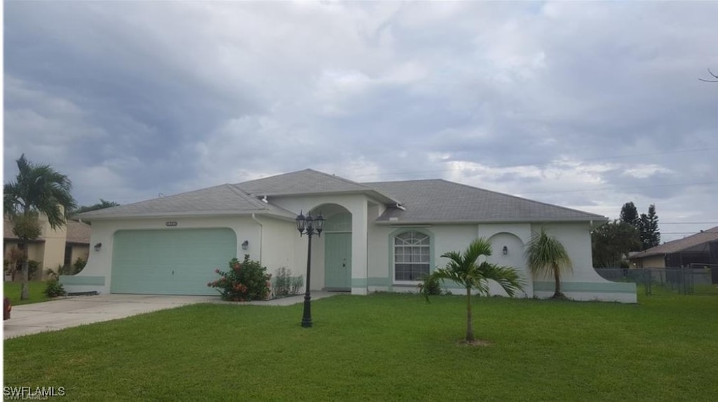 single story home featuring a front lawn and a garage