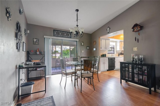 dining space featuring vaulted ceiling, light hardwood / wood-style flooring, and an inviting chandelier