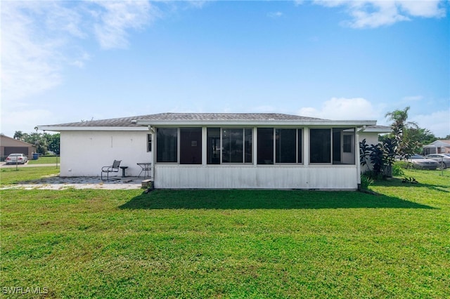 back of house with a sunroom and a yard