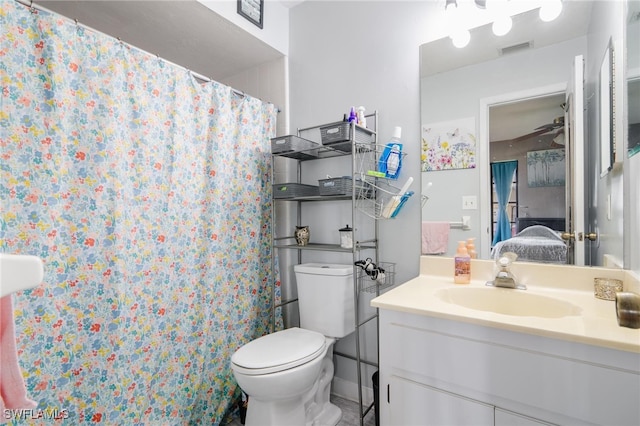 bathroom featuring a shower with shower curtain, vanity, toilet, and ceiling fan