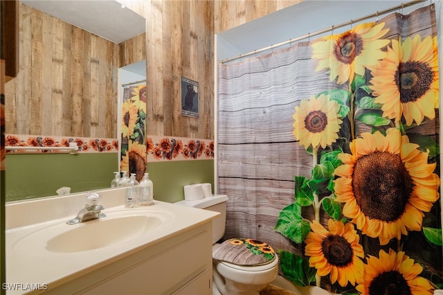 bathroom with wooden walls, vanity, and toilet