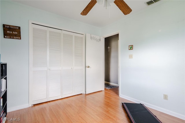 unfurnished bedroom featuring ceiling fan, light hardwood / wood-style flooring, and a closet