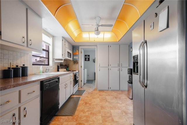 kitchen with white appliances, white cabinets, sink, ceiling fan, and decorative backsplash