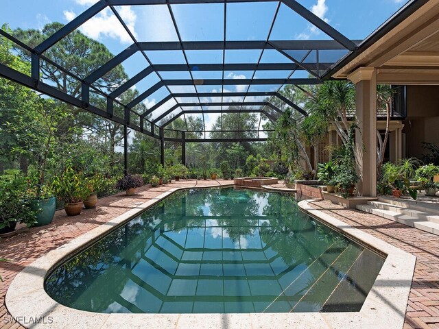 view of swimming pool with a lanai and an in ground hot tub