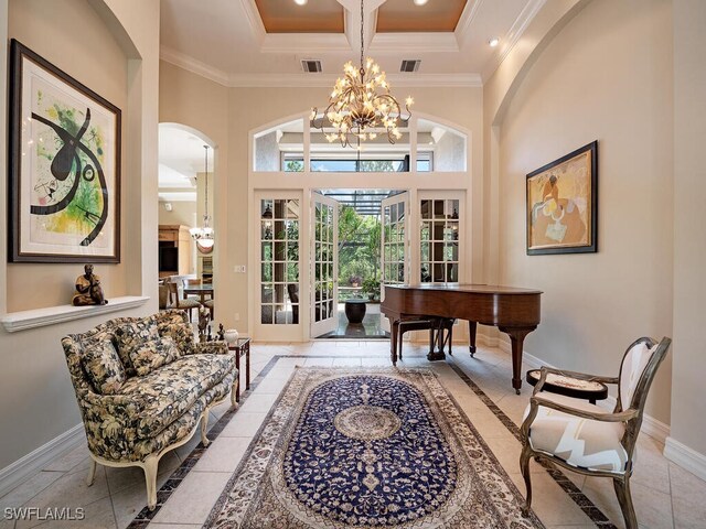 interior space featuring a high ceiling, ornamental molding, french doors, and a notable chandelier