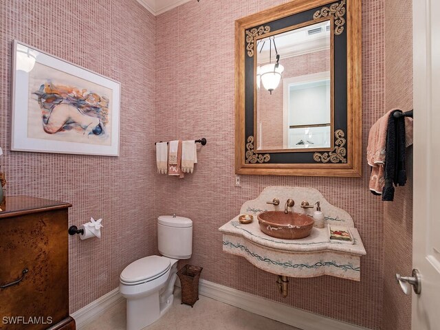 bathroom featuring ornamental molding, toilet, sink, and tile patterned flooring