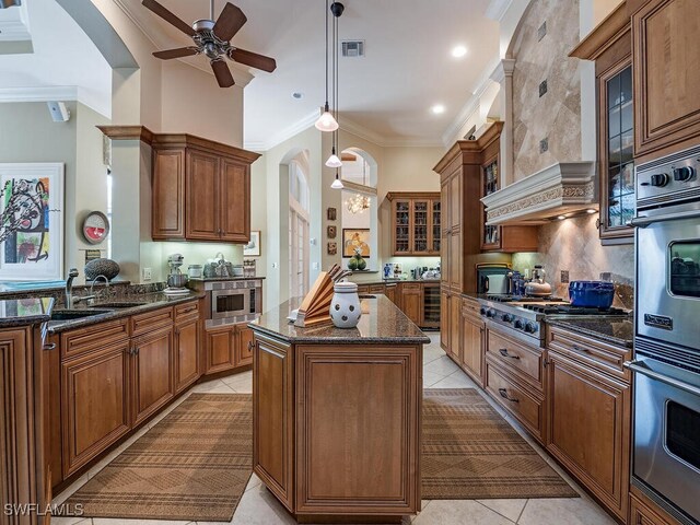 kitchen with light tile patterned floors, premium range hood, sink, a center island, and ceiling fan