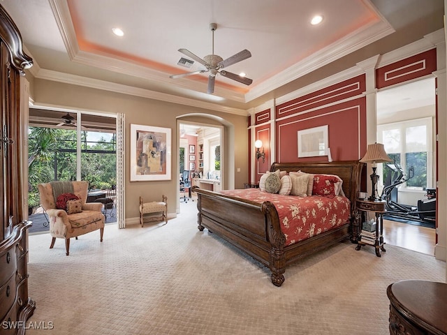 carpeted bedroom featuring a tray ceiling, ceiling fan, and ornamental molding