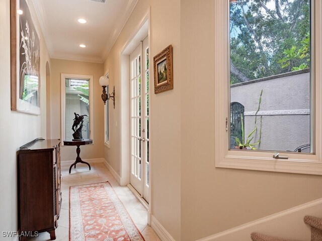 corridor with plenty of natural light, crown molding, and light tile patterned flooring