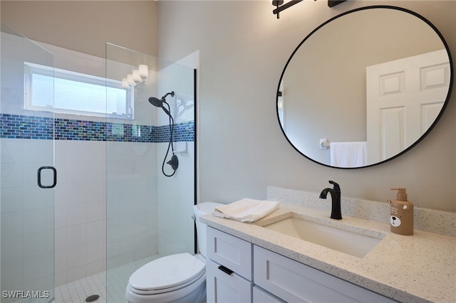 bathroom featuring vanity, toilet, and a shower with shower door