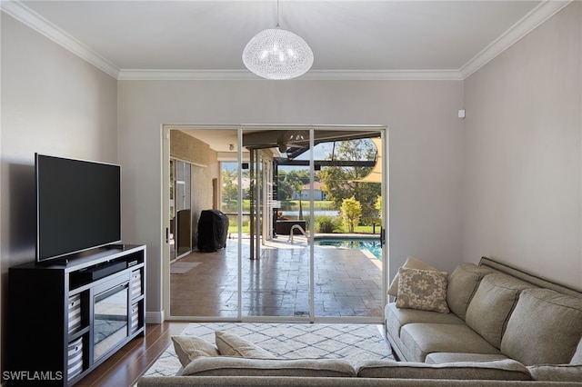 living room featuring an inviting chandelier, ornamental molding, and hardwood / wood-style floors