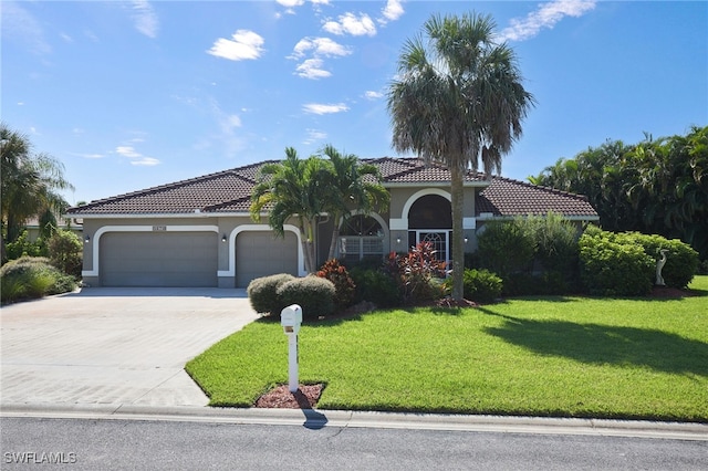 mediterranean / spanish house with a garage and a front yard