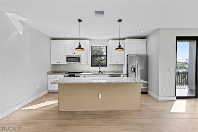 kitchen with a kitchen island, white cabinetry, stainless steel appliances, and light hardwood / wood-style flooring