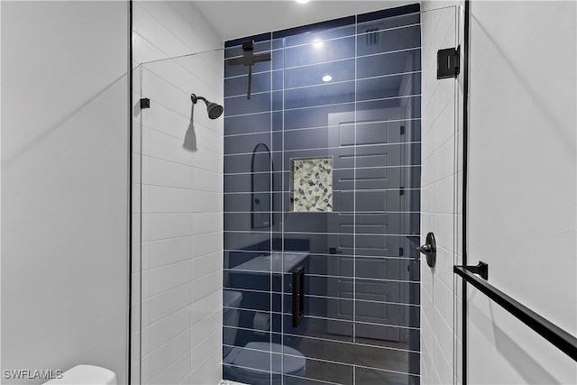 bathroom featuring toilet and tiled shower