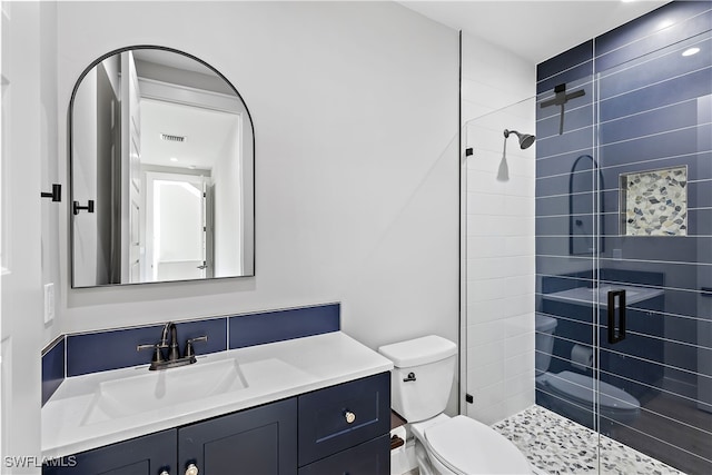 bathroom featuring a shower with door, vanity, and toilet