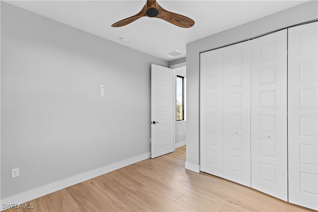 unfurnished bedroom featuring ceiling fan, light hardwood / wood-style flooring, and a closet