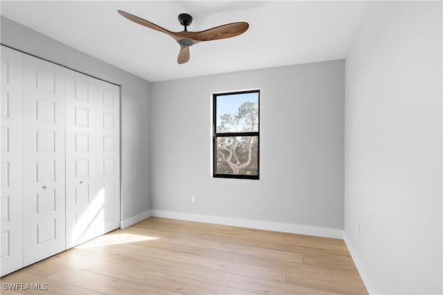 unfurnished bedroom featuring ceiling fan, a closet, and light wood-type flooring