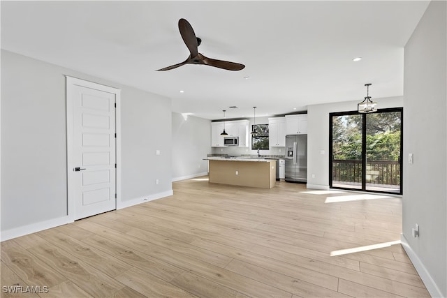 unfurnished living room with ceiling fan and light wood-type flooring