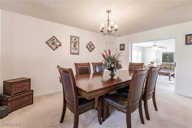 dining room with a textured ceiling, light carpet, and a notable chandelier