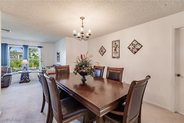 dining space with light carpet, a textured ceiling, and a notable chandelier